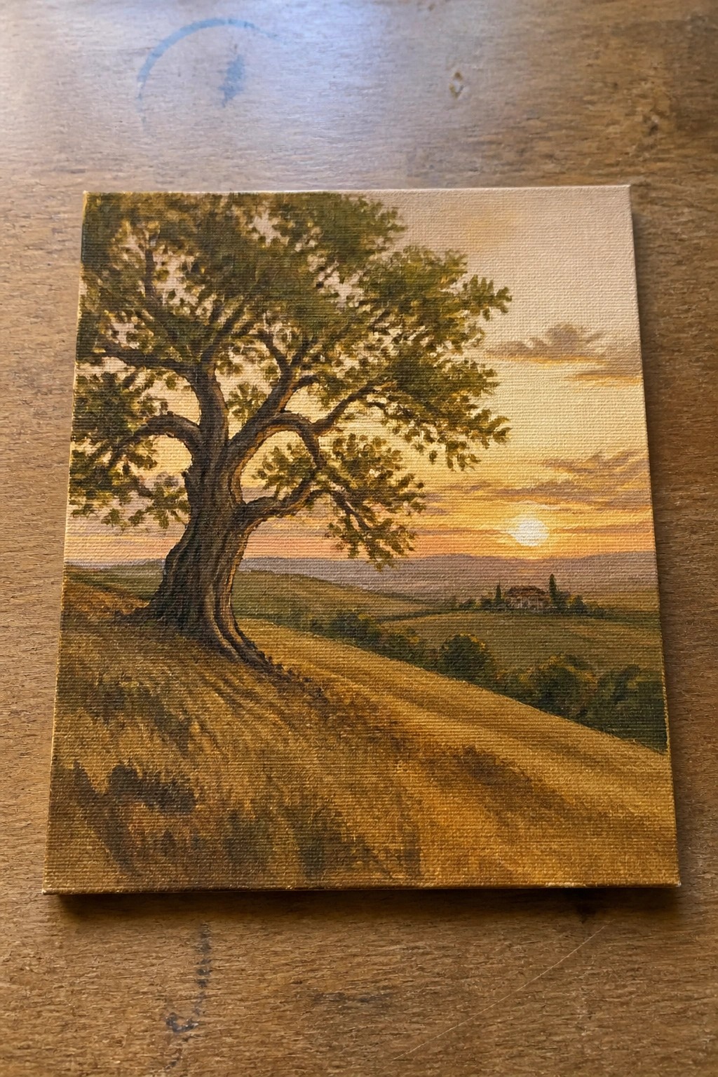 Landscape painting of large tree in golden fields at vibrant sunset with distant hills