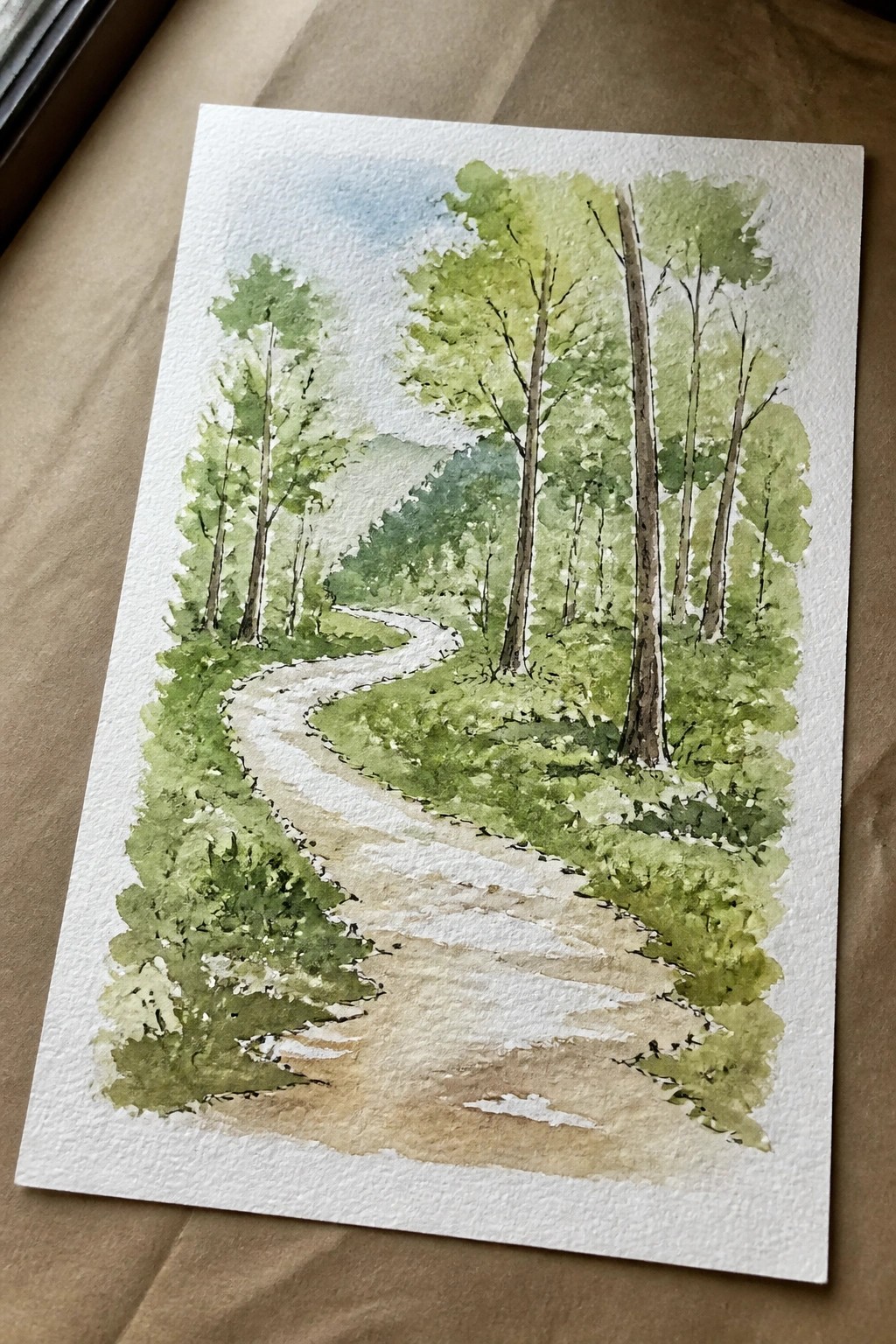 Watercolor painting of a winding dirt path through lush green forest trees