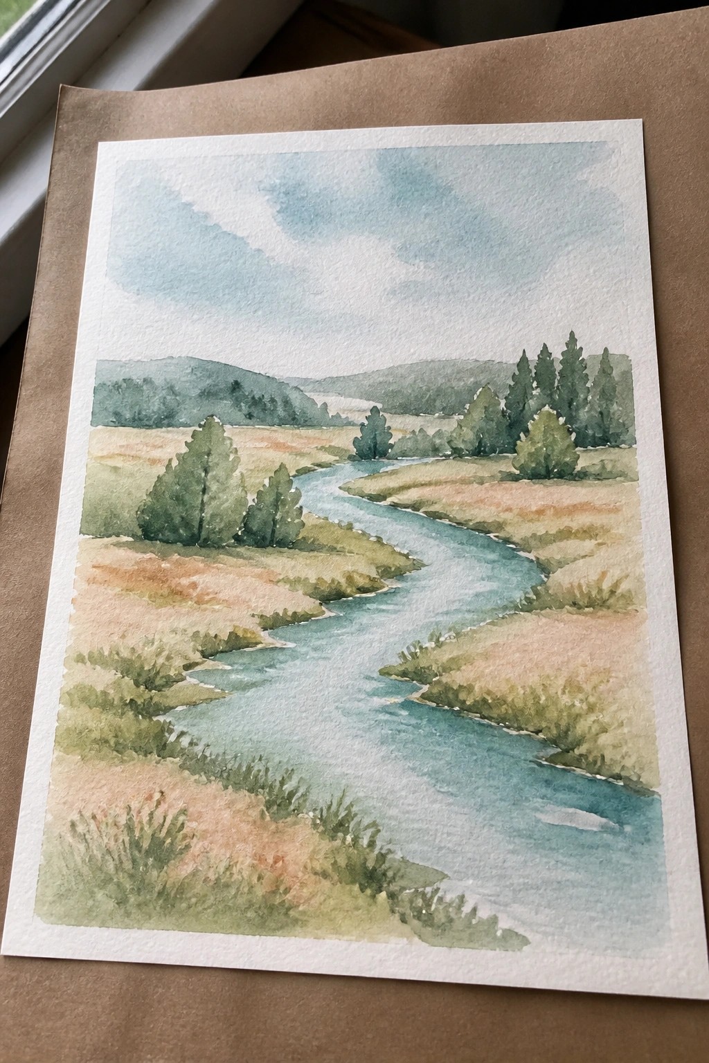 Watercolor landscape of winding blue river through fields, trees, and distant hills