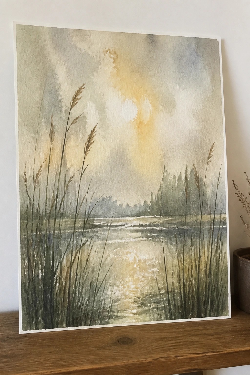 Watercolor landscape of misty lake with tall reeds and glowing sunlight reflections