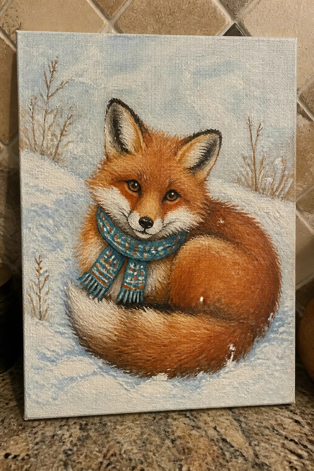 Red fox wearing blue patterned scarf curled in snowy winter landscape
