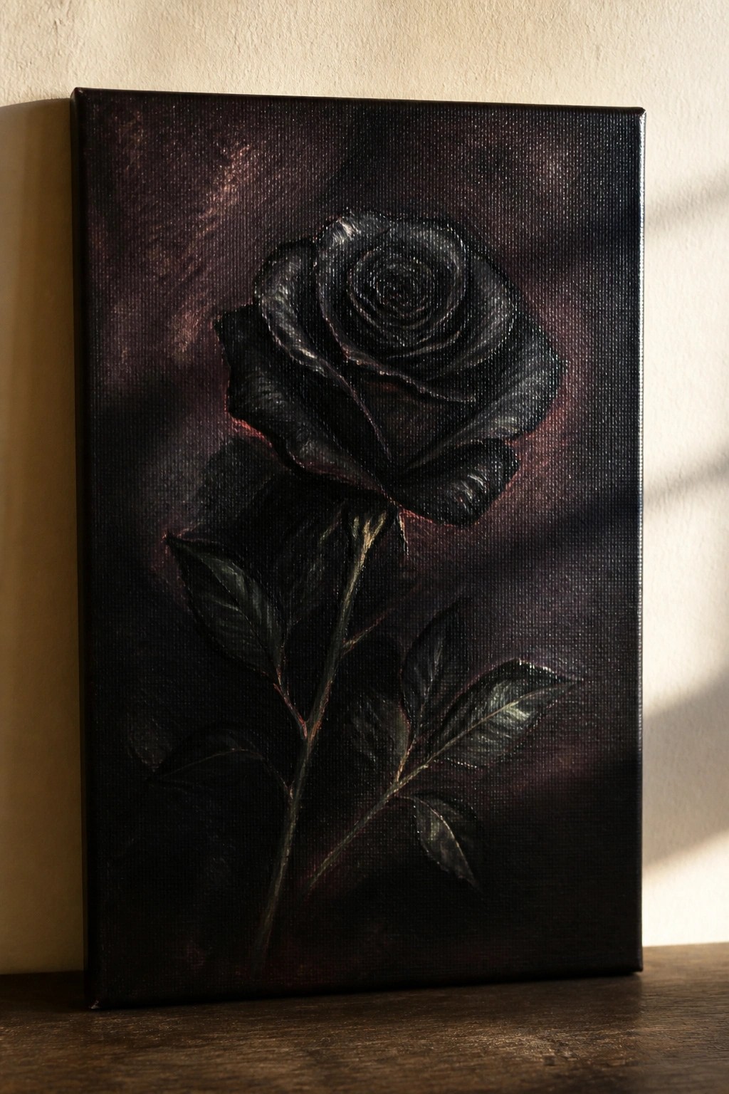 Painting of a black rose with stem and leaves on dark canvas