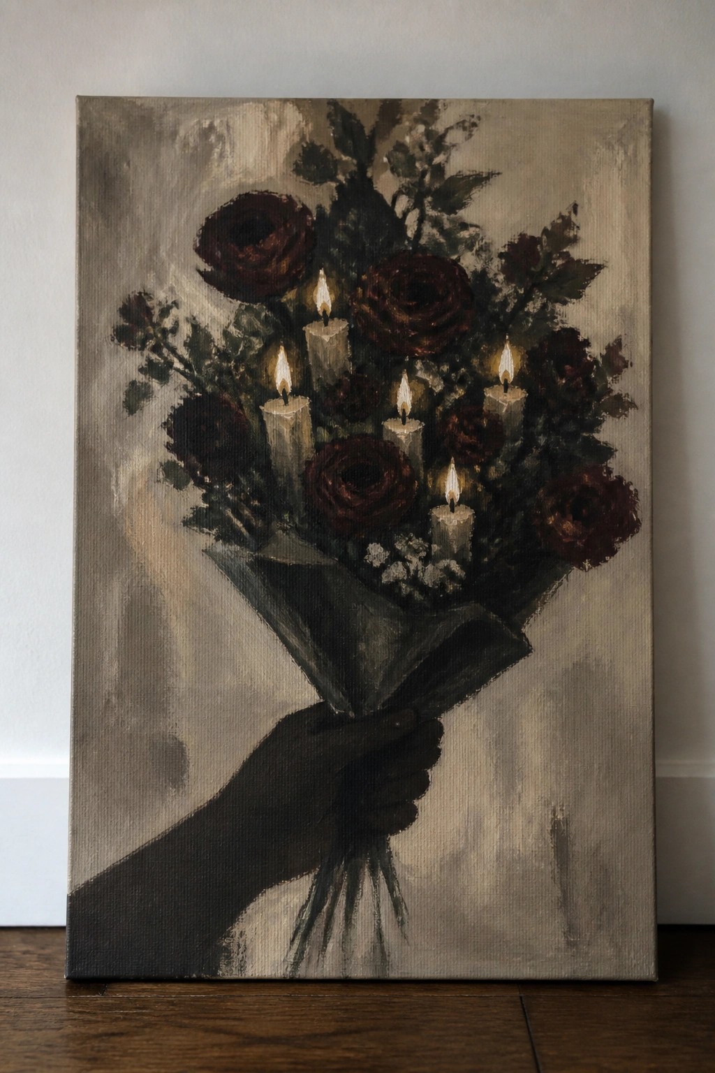 Silhouetted hand holding bouquet of dark roses with several lit candles.