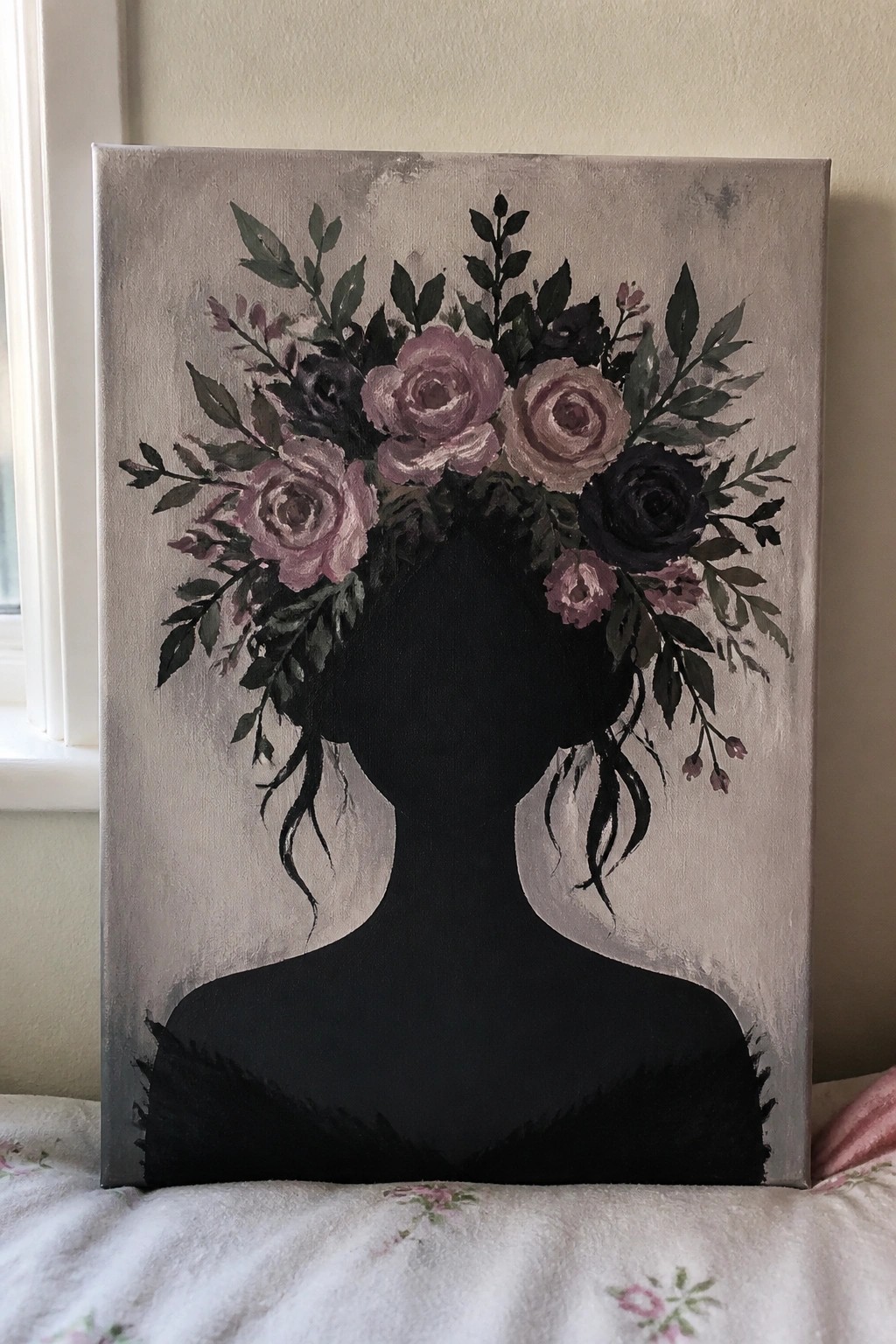 Black silhouette of a woman with pink and black roses blooming from her head