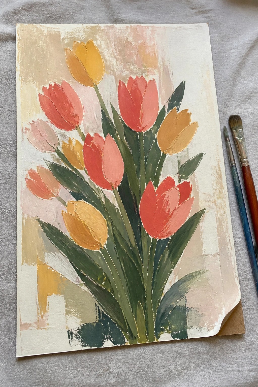 Vibrant tulip painting with red, yellow, and pink blooms, green leaves, and nearby brushes