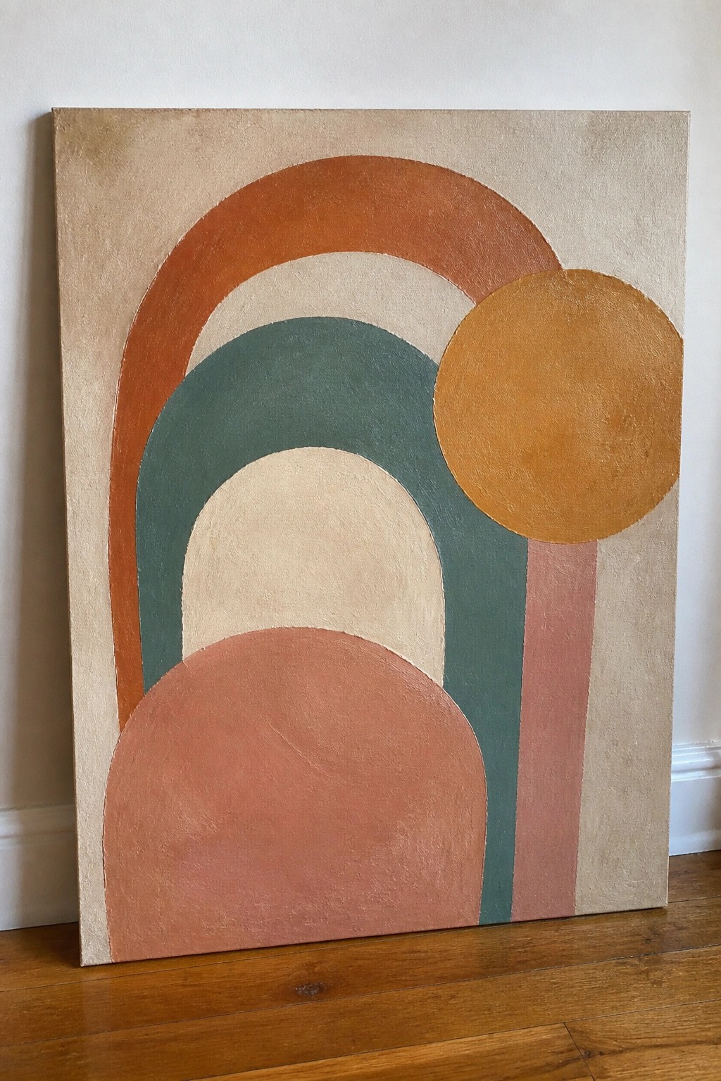 Abstract canvas with terracotta arches, teal curves, and orange circle against wall.