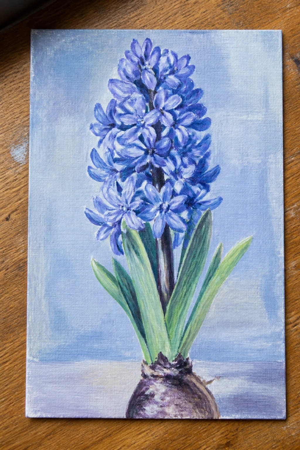 Canvas painting of purple hyacinth blooms, green leaves, and bulb