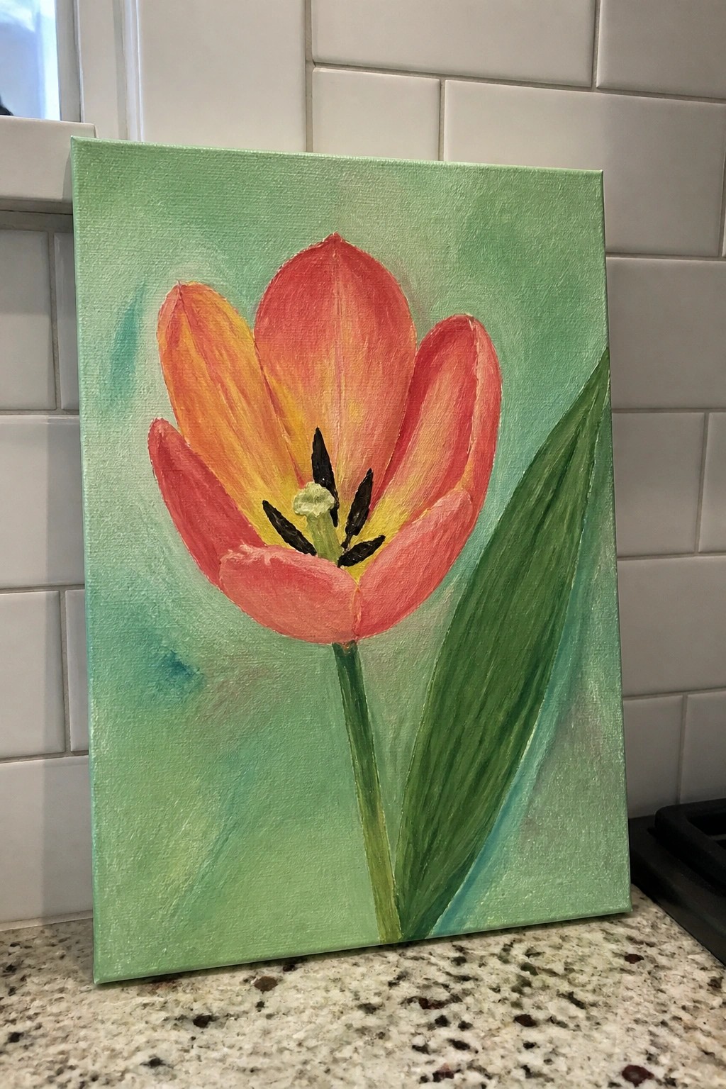 Red-orange tulip painting with yellow center, green stem, on light green canvas.