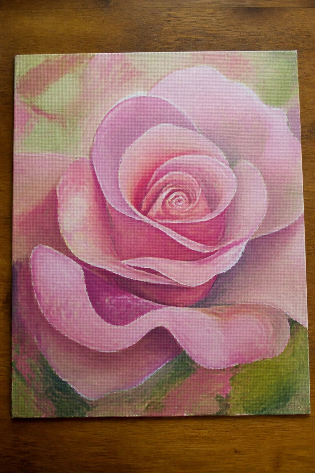 Pink rose with layered petals painted on canvas over wooden surface