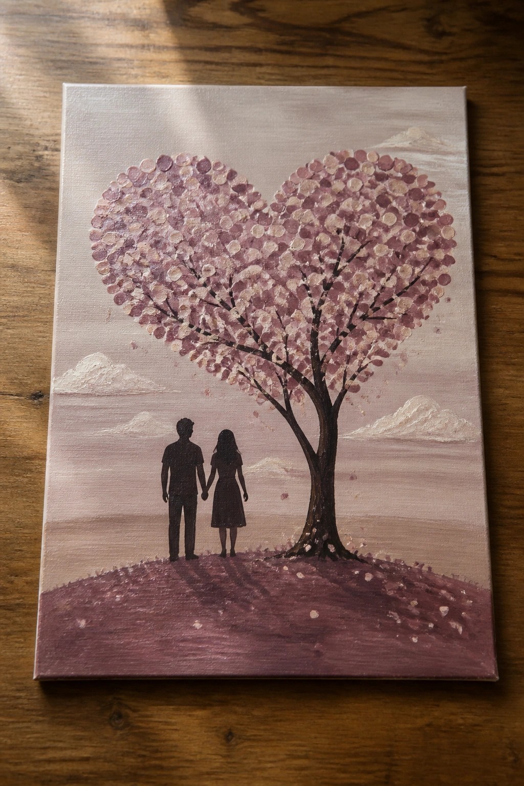 Silhouetted couple holding hands under heart-shaped pink blossom tree on purple hill