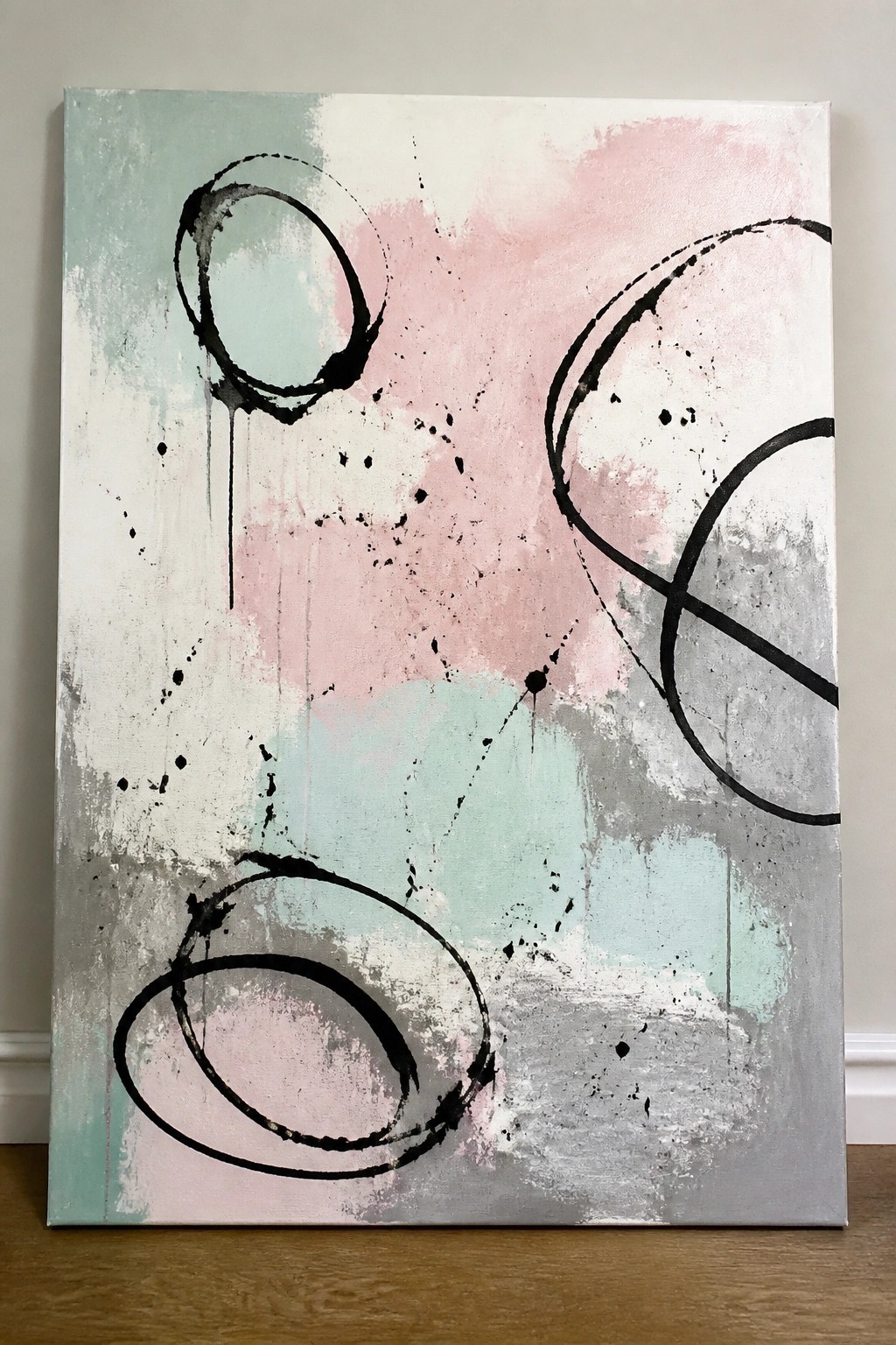 Abstract canvas with black loops and drips on pastel pink, mint, and gray washes