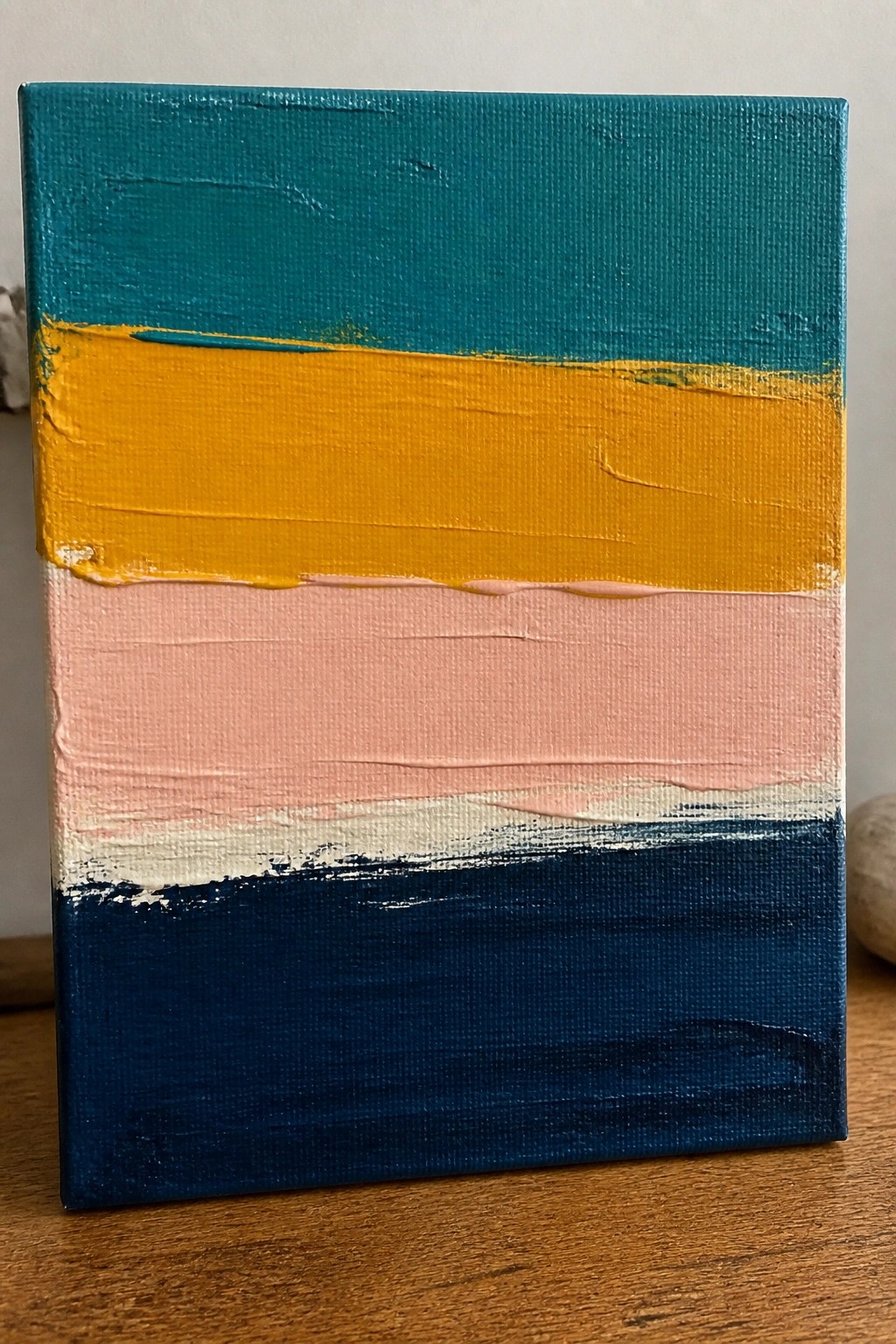 Abstract painting with thick horizontal stripes of teal, yellow, pink, white, and navy blue.