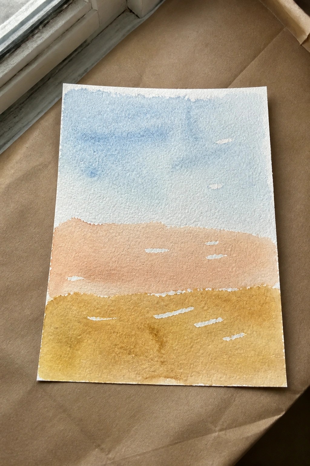 Watercolor painting with blue sky above peach and yellow bands with white dashes