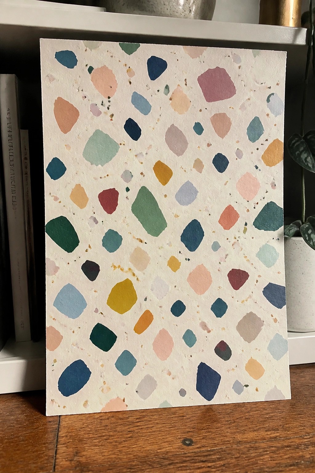 Terrazzo-style card with scattered colorful irregular shapes on white speckled paper.
