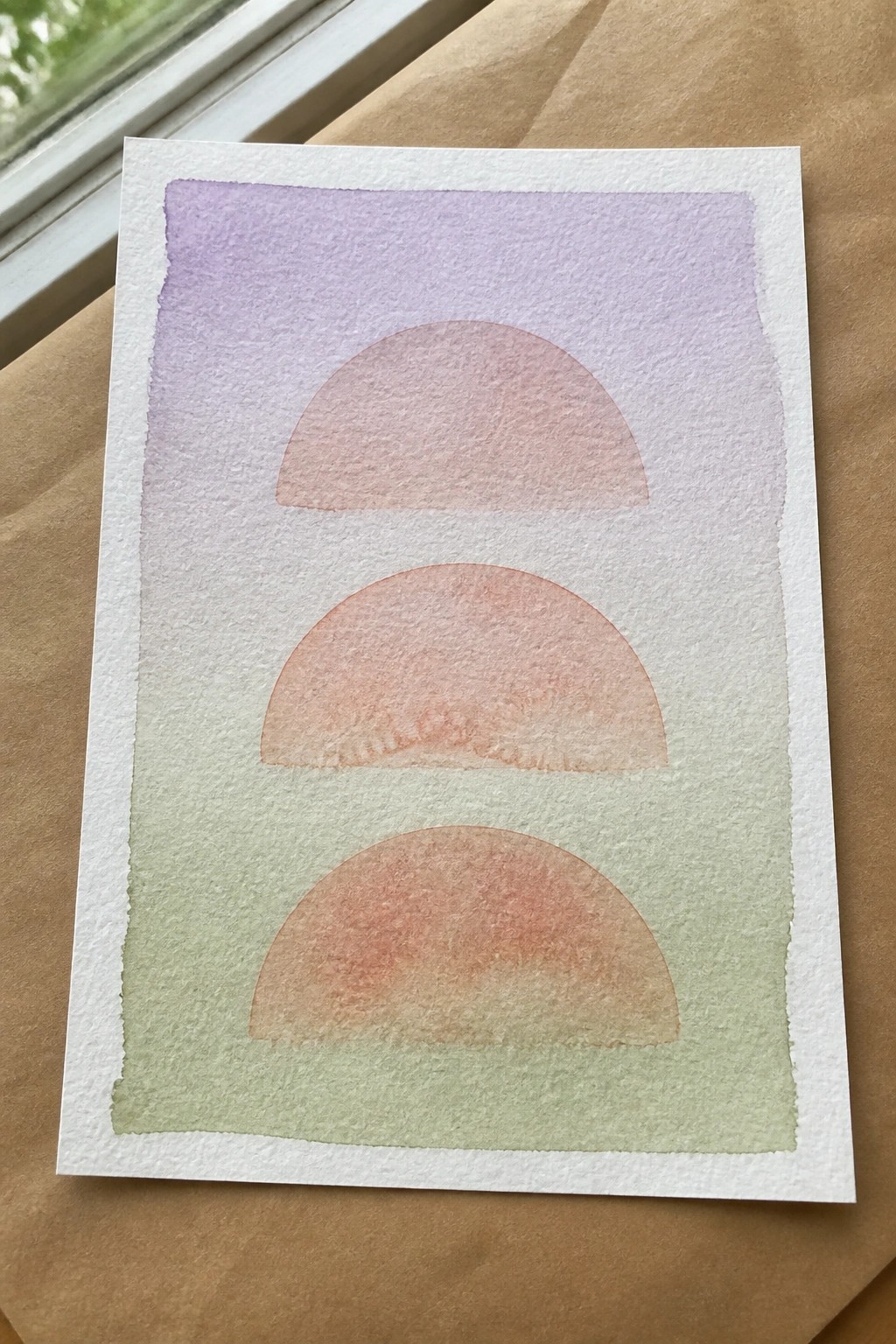 Watercolor artwork featuring three pink-orange semicircles on purple-to-green gradient background.