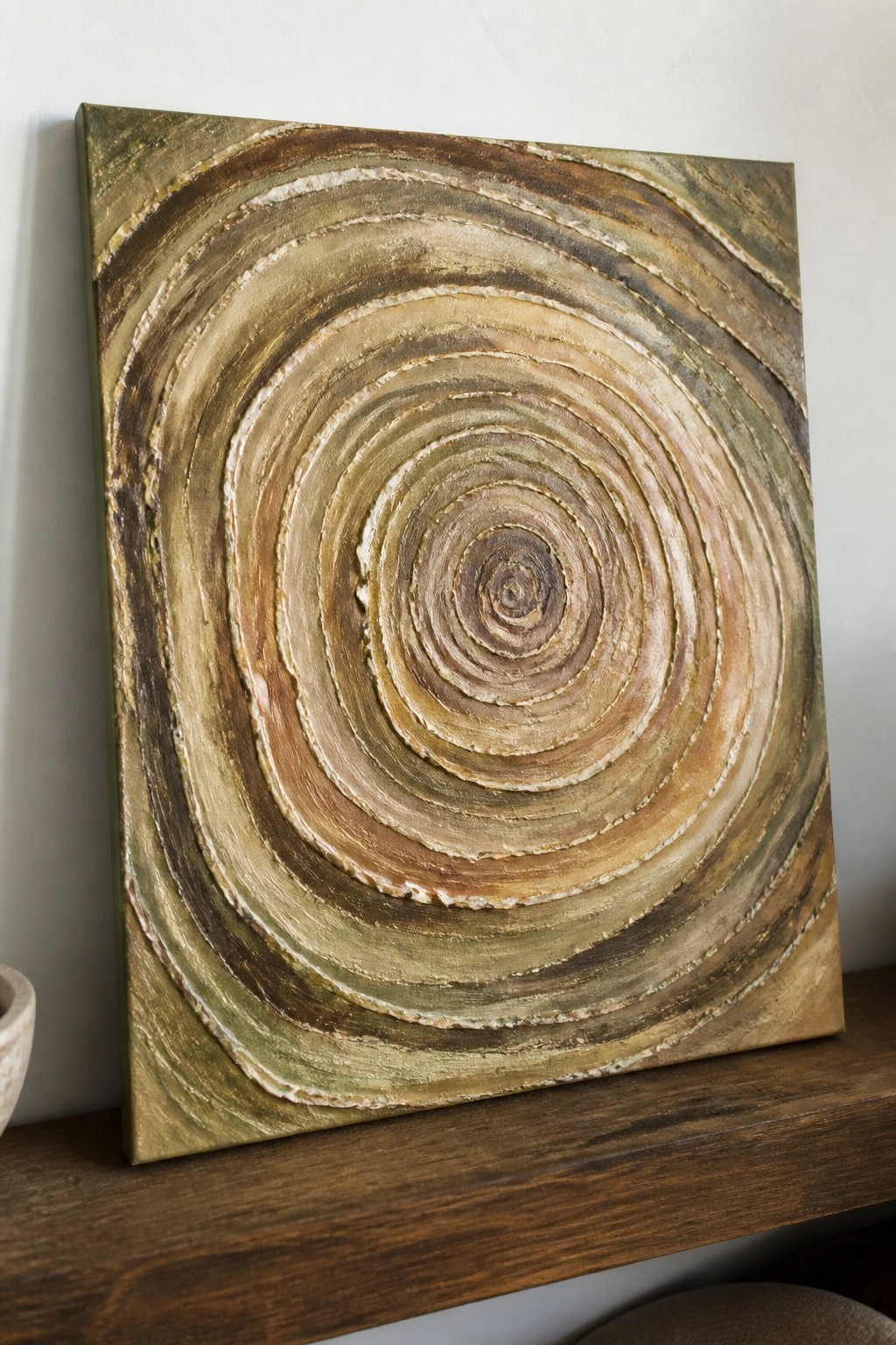 Abstract painting with textured concentric circles in earthy brown and green tones on wood