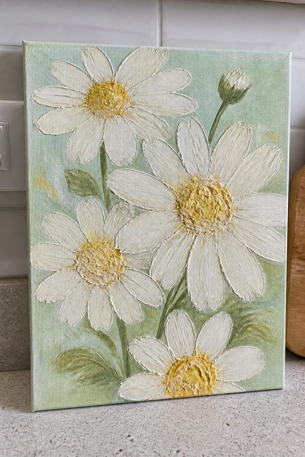 Textured canvas painting of white daisies with yellow centers on light green background