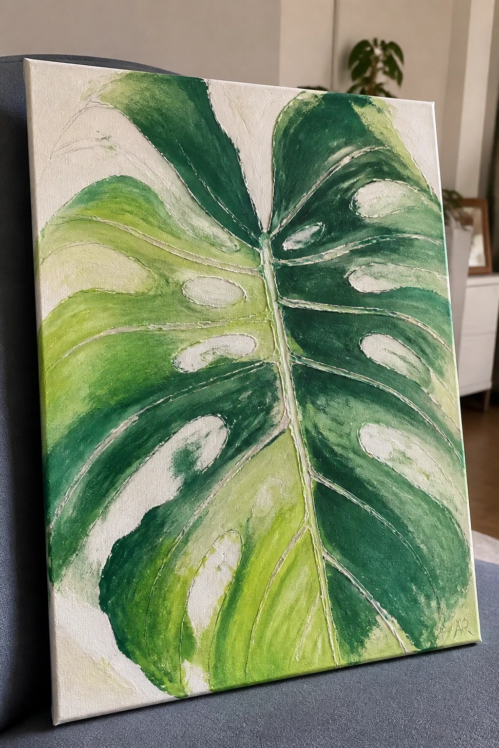 Green monstera leaf painting with layered shades on white canvas