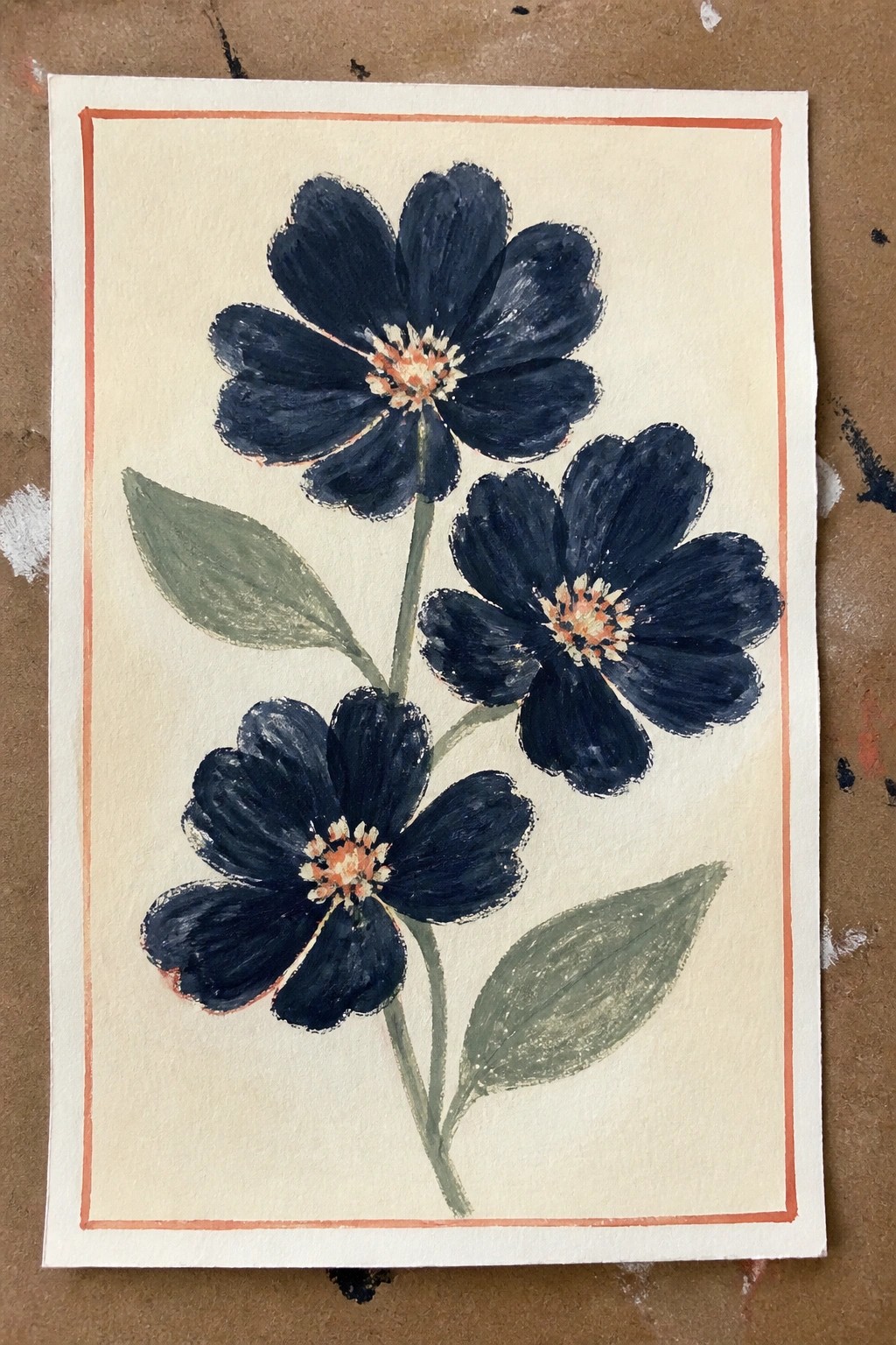 Watercolor of three dark blue flowers with orange centers inside orange border