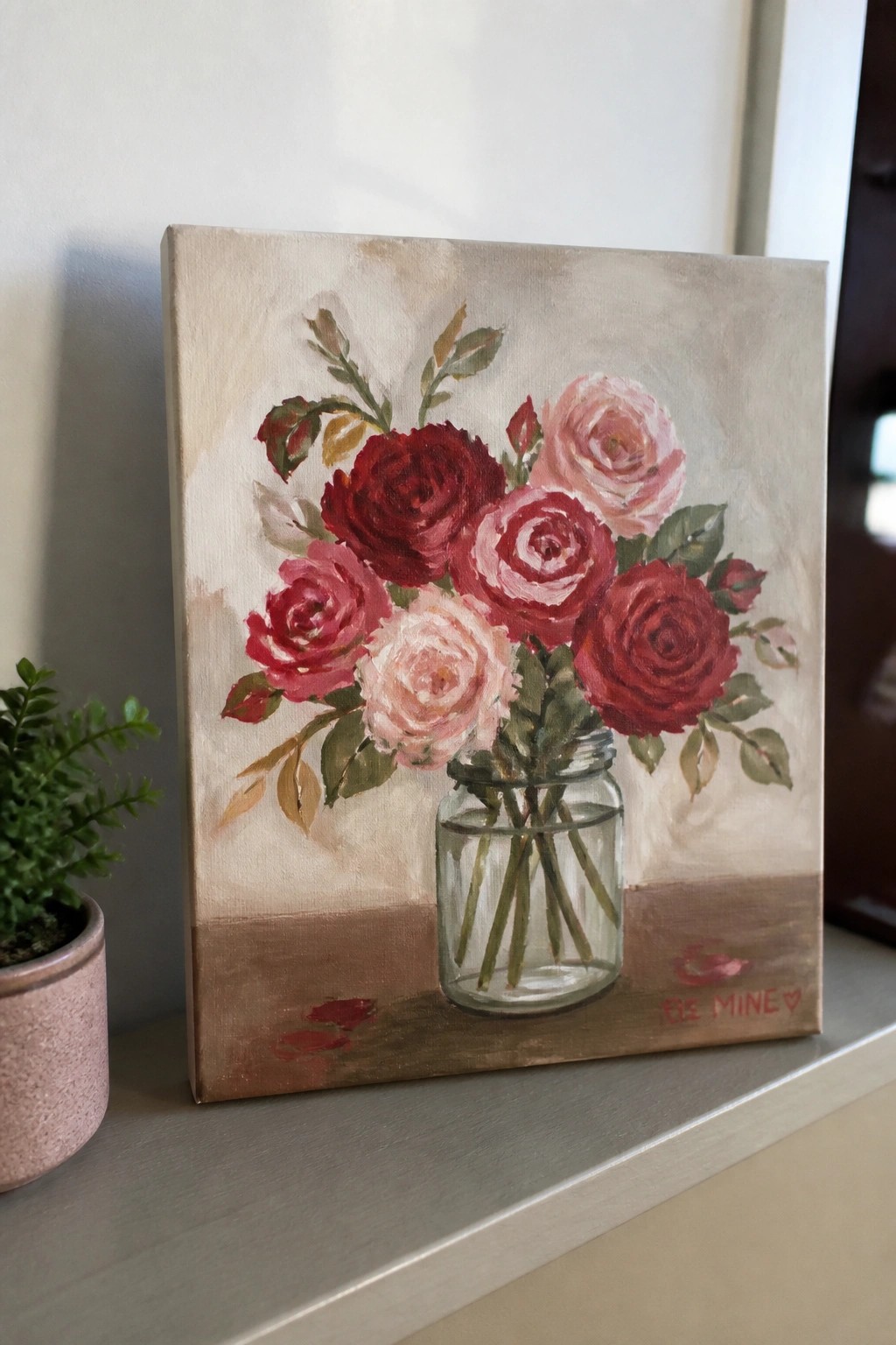 Painting of red and pink roses in glass jar labeled