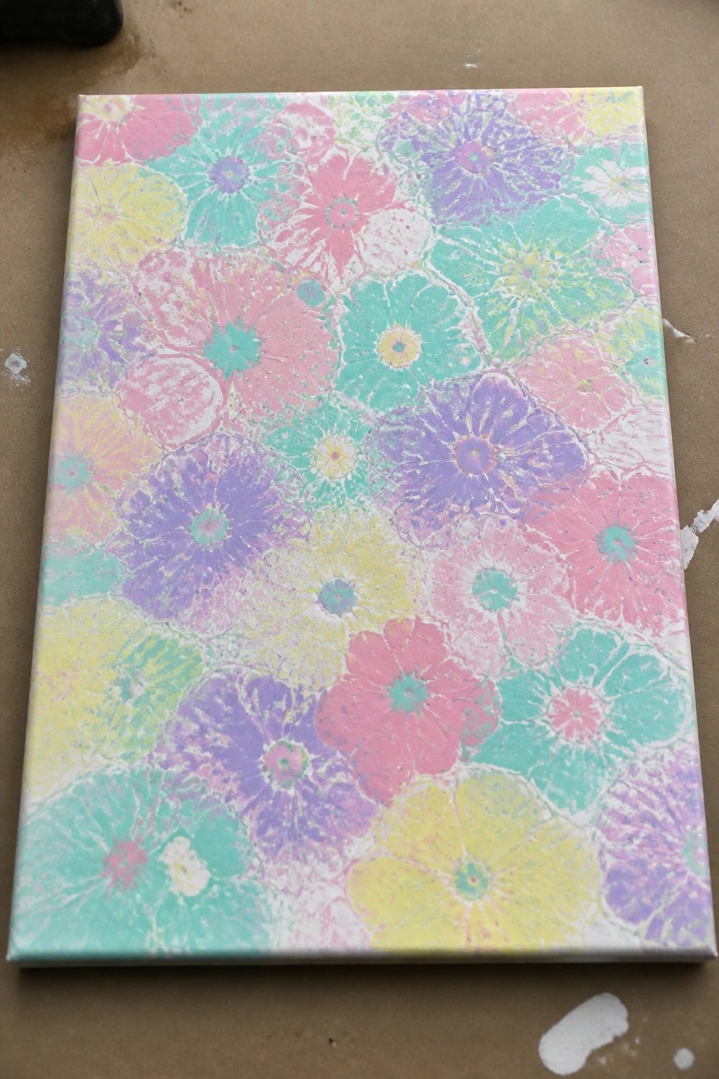 Vibrant canvas with overlapping pastel flowers in pink, purple, yellow, and turquoise.