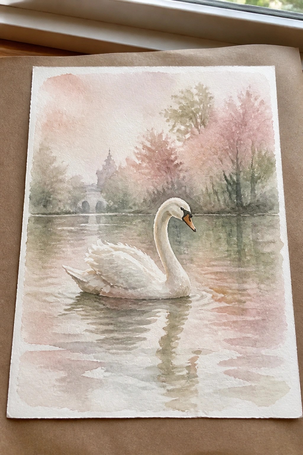 Watercolor of white swan on calm water with pink misty trees and distant pavilion.