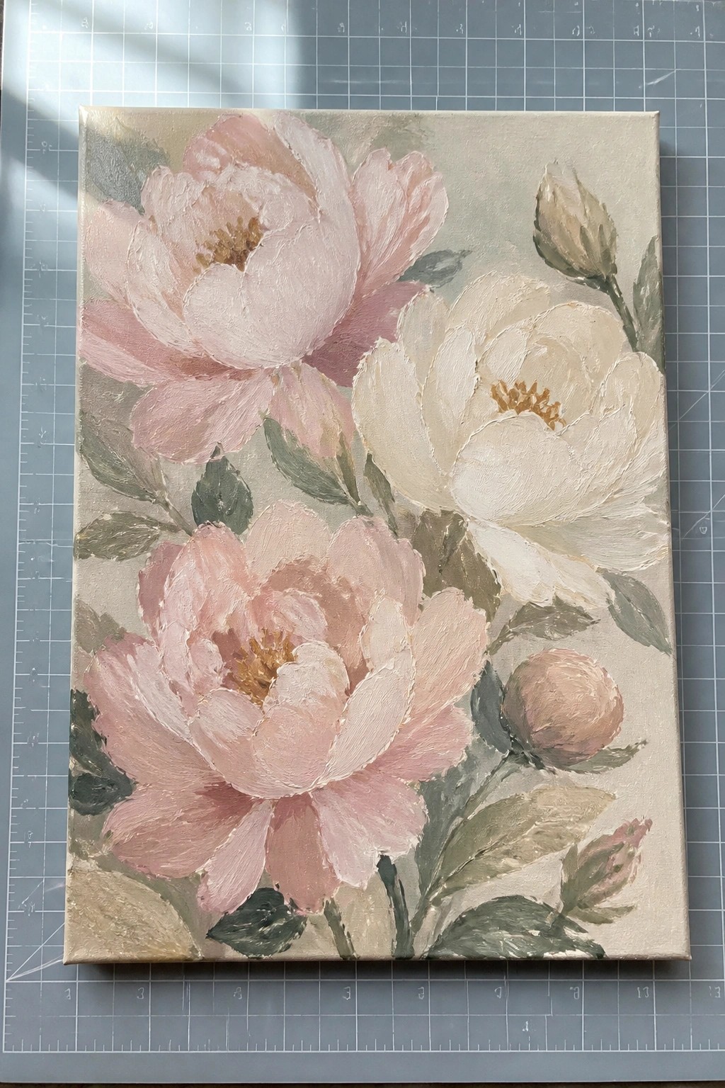 Painting of large pink and white peonies with green leaves on canvas