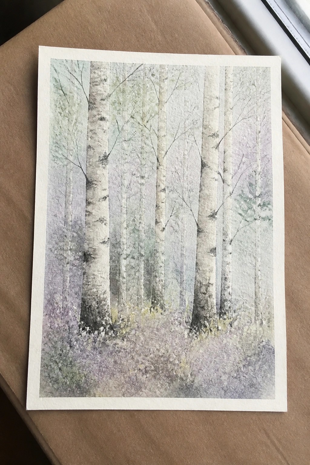 Watercolor of slender white birch trunks in a soft pastel misty forest