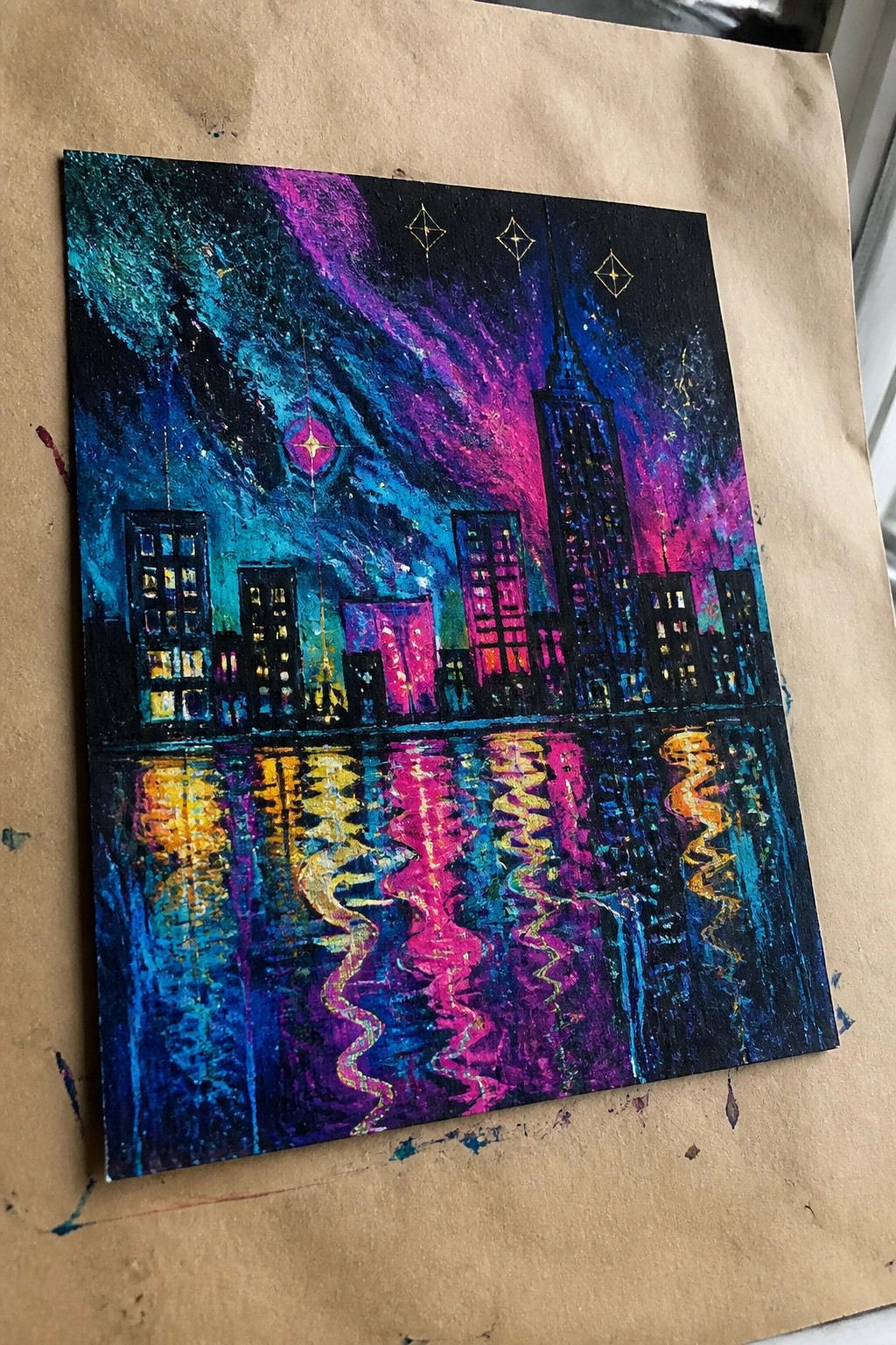 Colorful abstract painting of glowing city skyline with vibrant reflections in water under starry sky