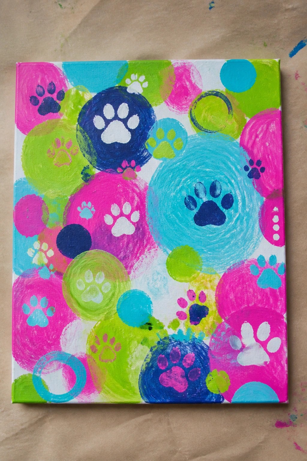 Vibrant canvas with overlapping neon circles and colorful paw prints.