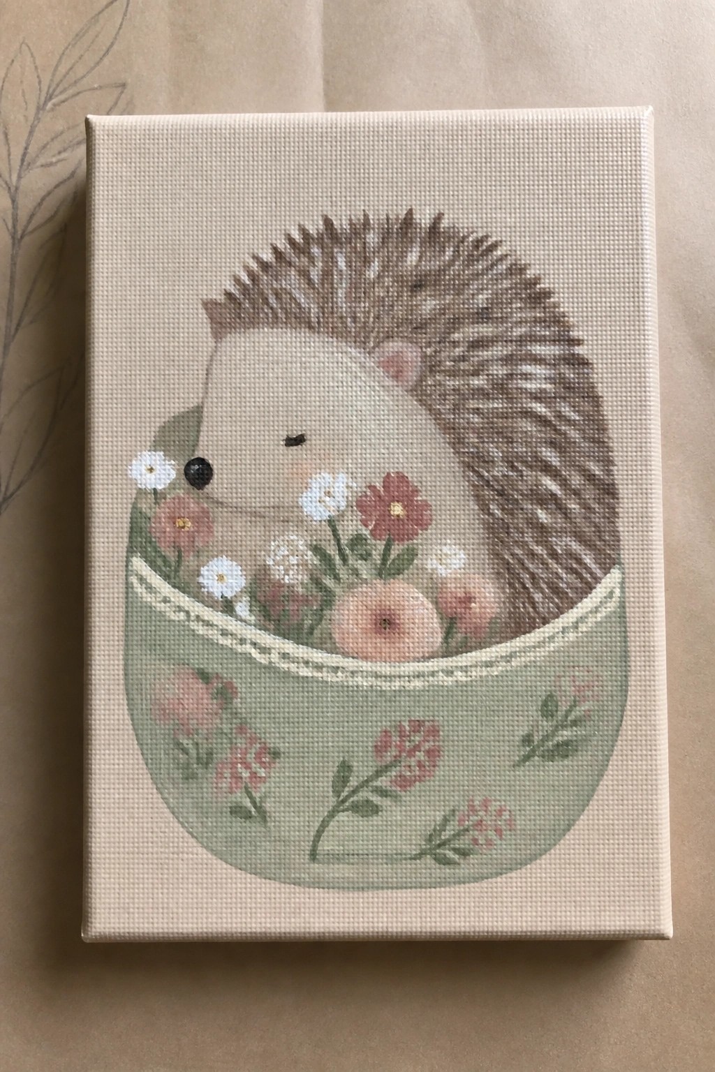 Cute hedgehog nestled in a floral green bowl on beige canvas