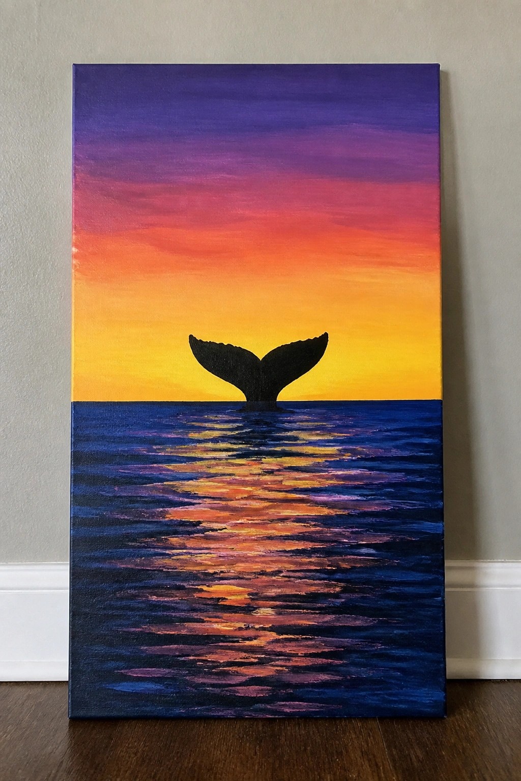 Whale tail silhouette against vibrant purple-orange sunset over reflective blue ocean waves