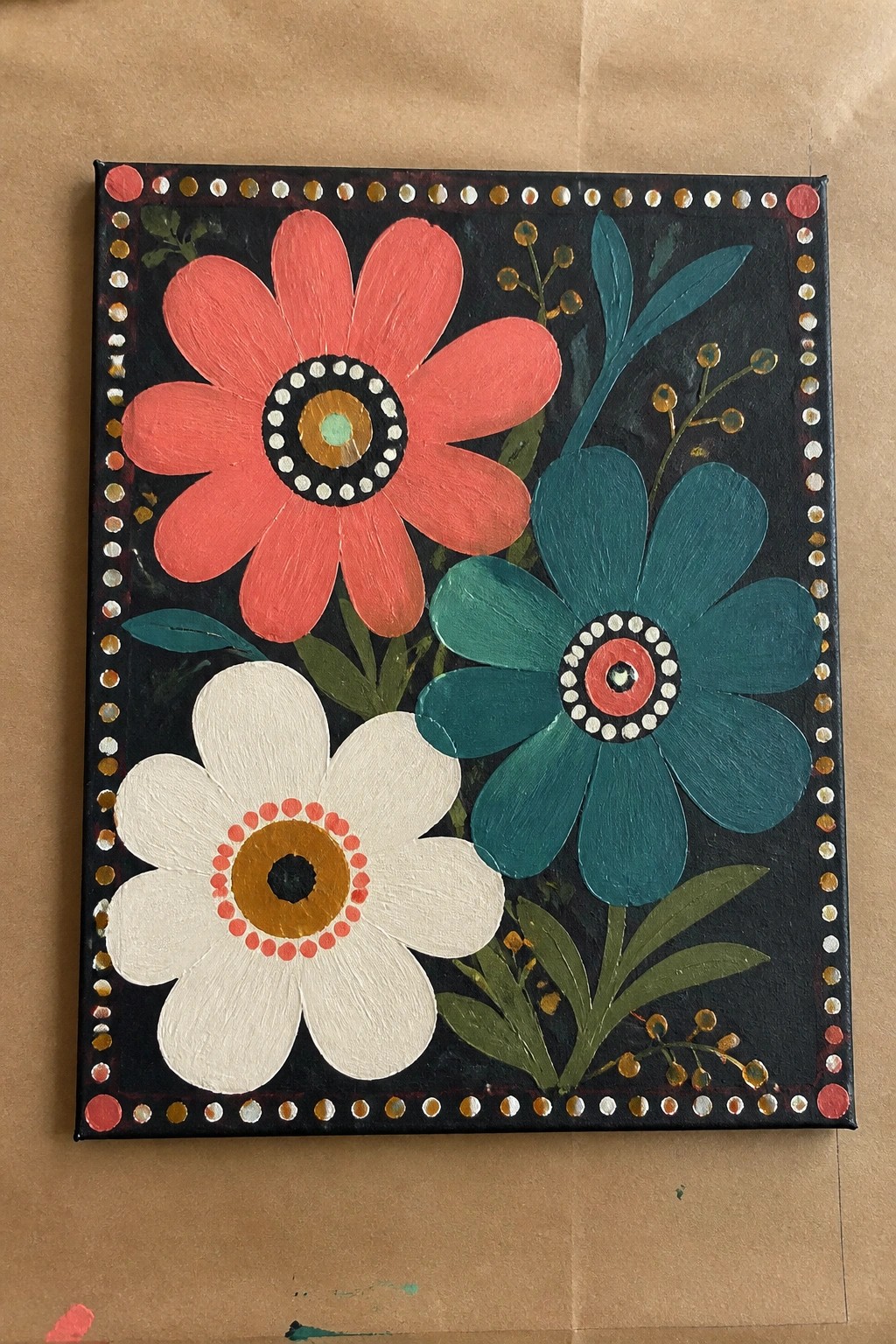 Colorful folk painting of three flowers with dotted border on black canvas.