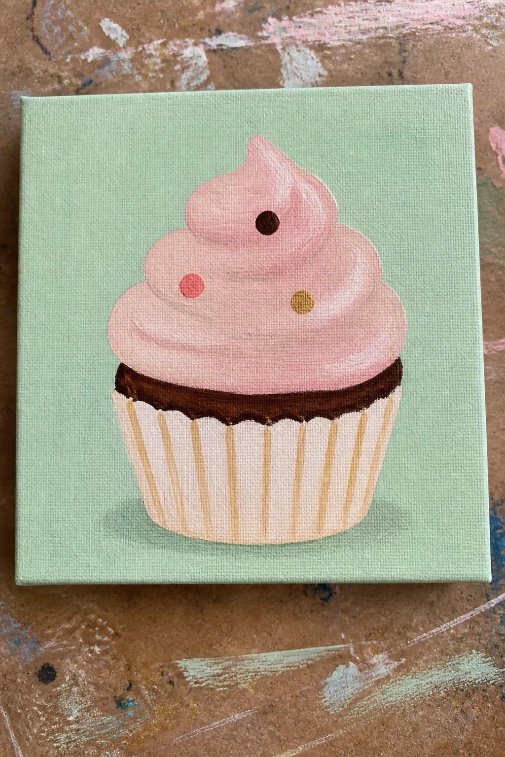 Pink frosted cupcake with polka dots on mint green canvas painting