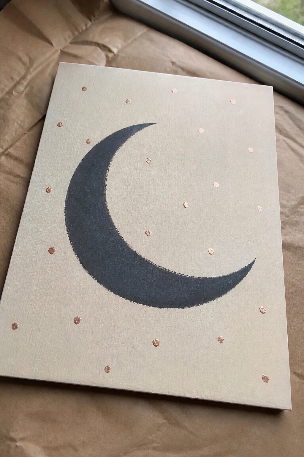 Cream canvas with dark crescent moon and scattered rose gold dots on brown paper