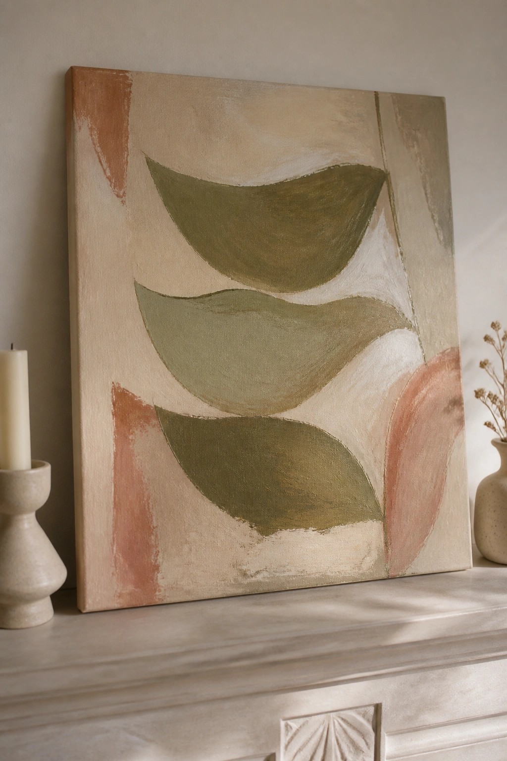 Abstract painting with curved green and terracotta shapes on mantel beside candle and vase
