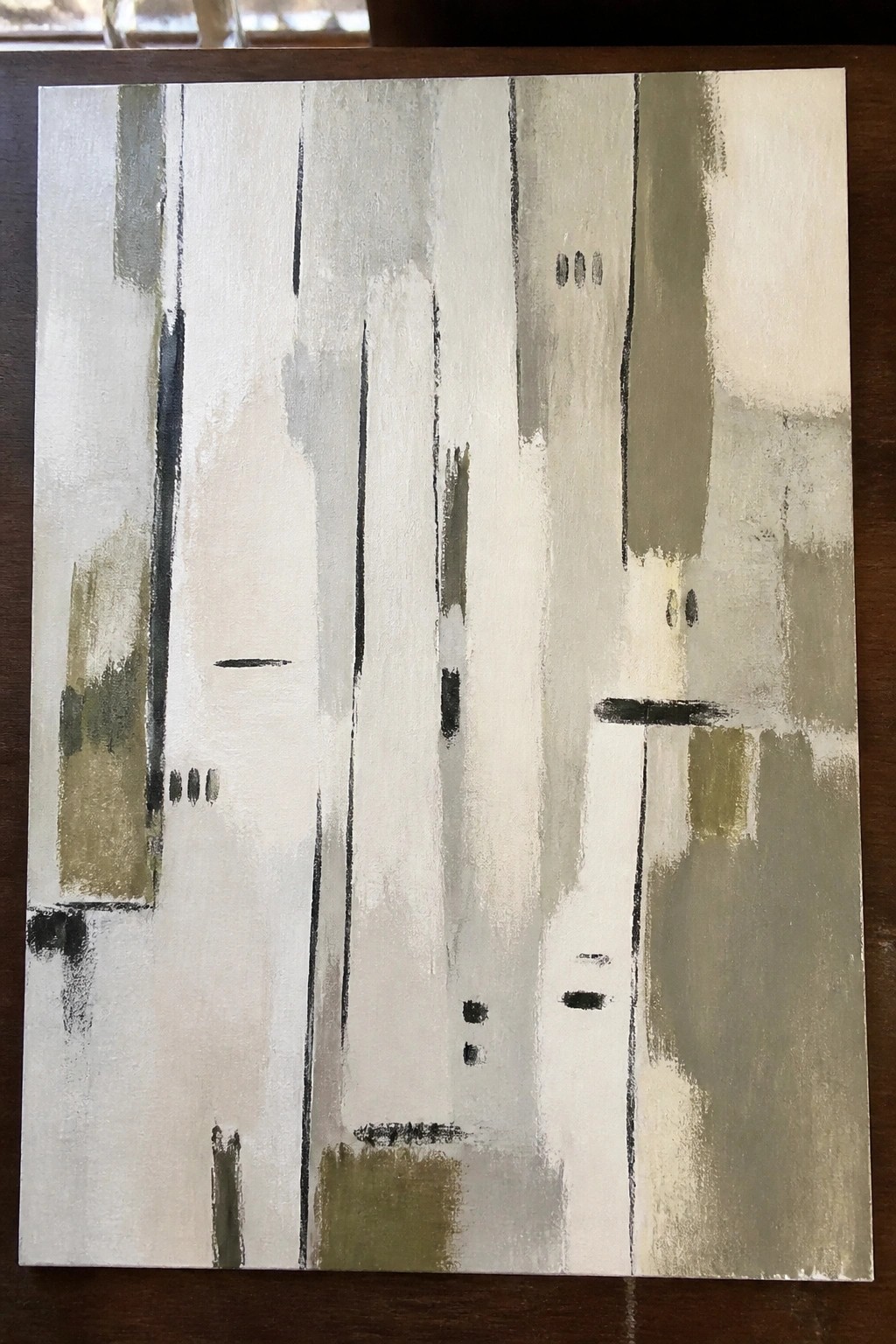 Abstract painting with vertical brushstrokes in white, gray, olive, and black