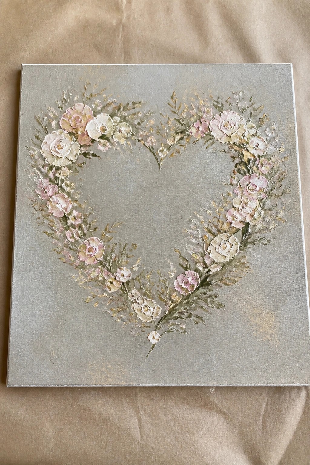 Floral heart wreath of pink and white roses with gold accents on gray canvas.