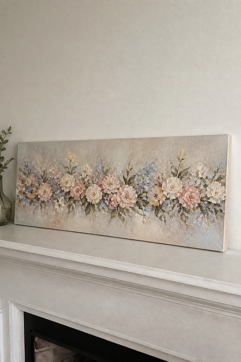 Wide floral painting with pink roses and blue blooms on white mantel