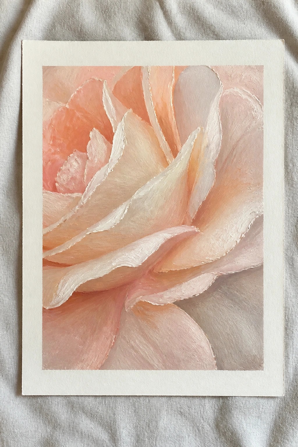 Textured painting of a blooming peach rose with soft pink layered petals on white mat.