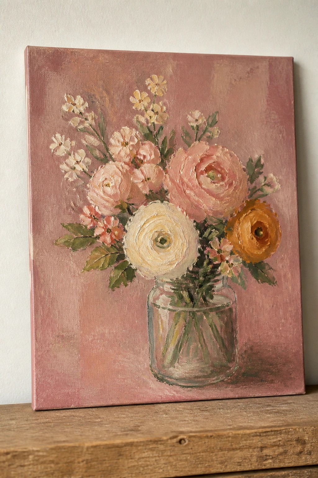 Oil painting of pink, white, and orange flowers in a glass jar on wood