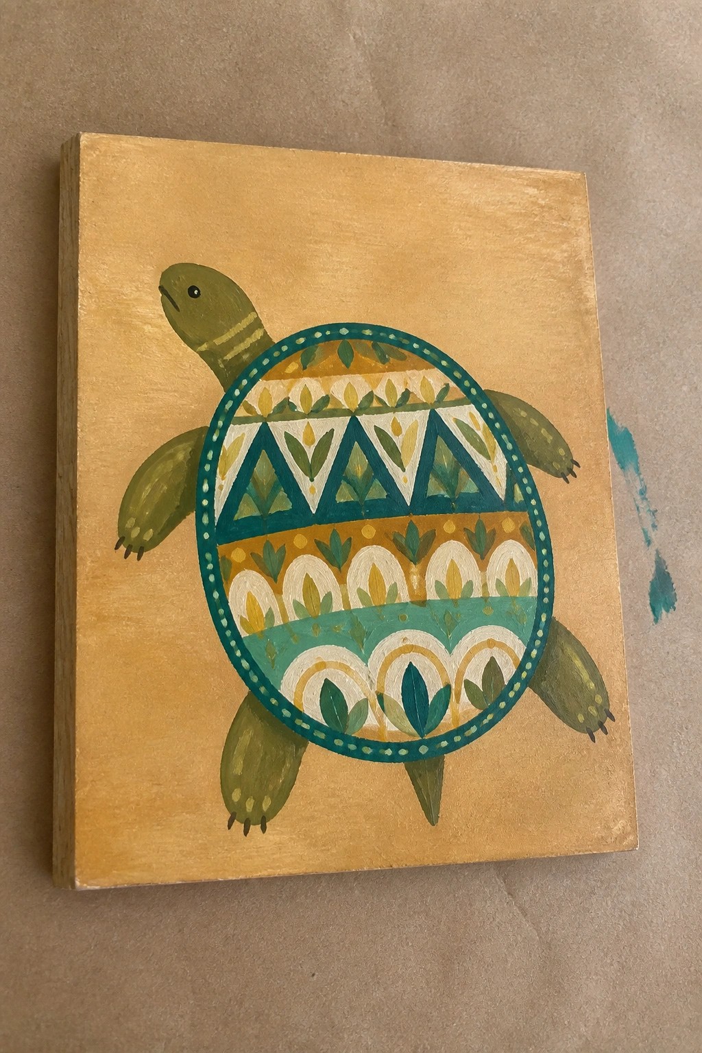 Vibrant folk-art turtle with patterned teal and gold shell on yellow canvas