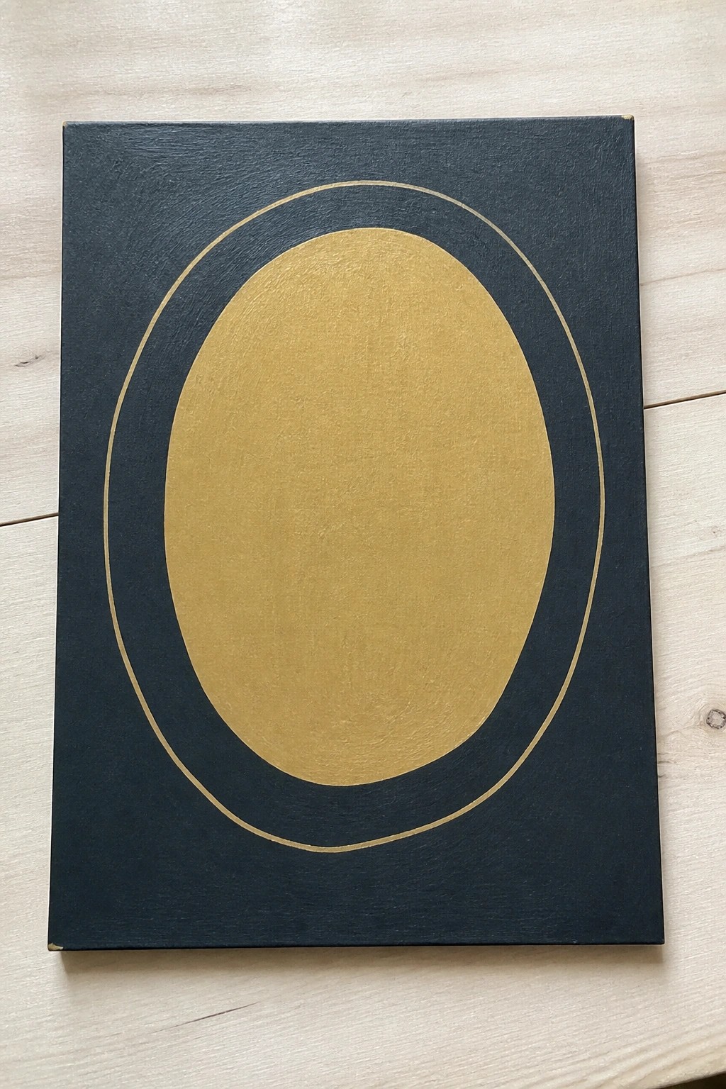 Abstract painting on dark navy canvas with large centered gold oval and thin border