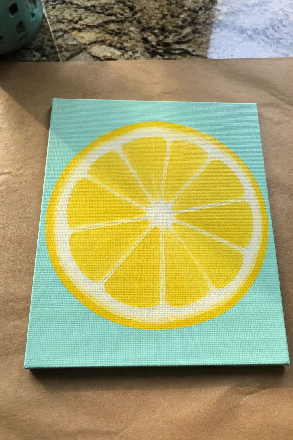 Yellow lemon slice with white segments on square light turquoise canvas