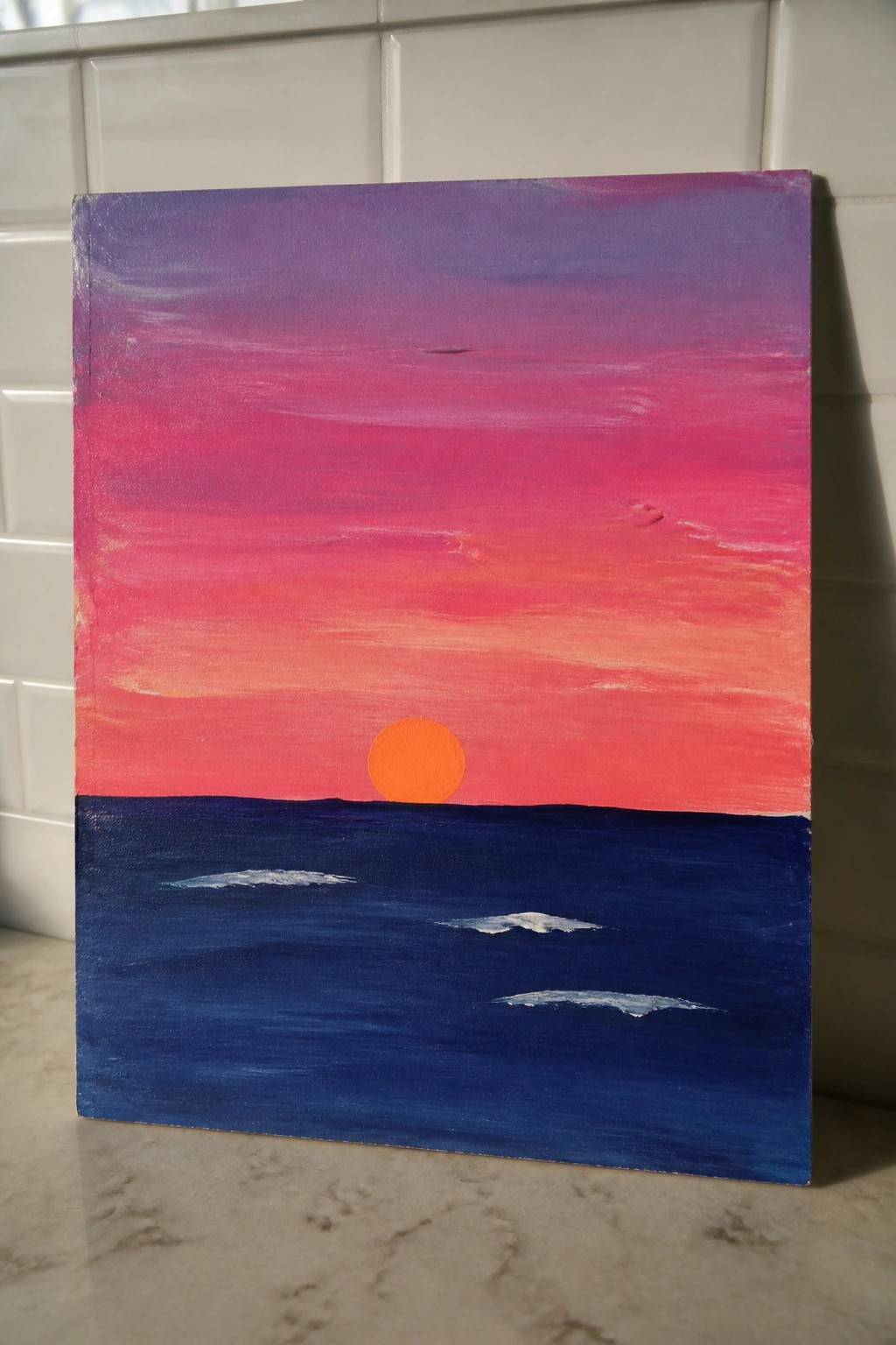 Vibrant sunset painting with orange sun over dark blue ocean and pink-purple sky