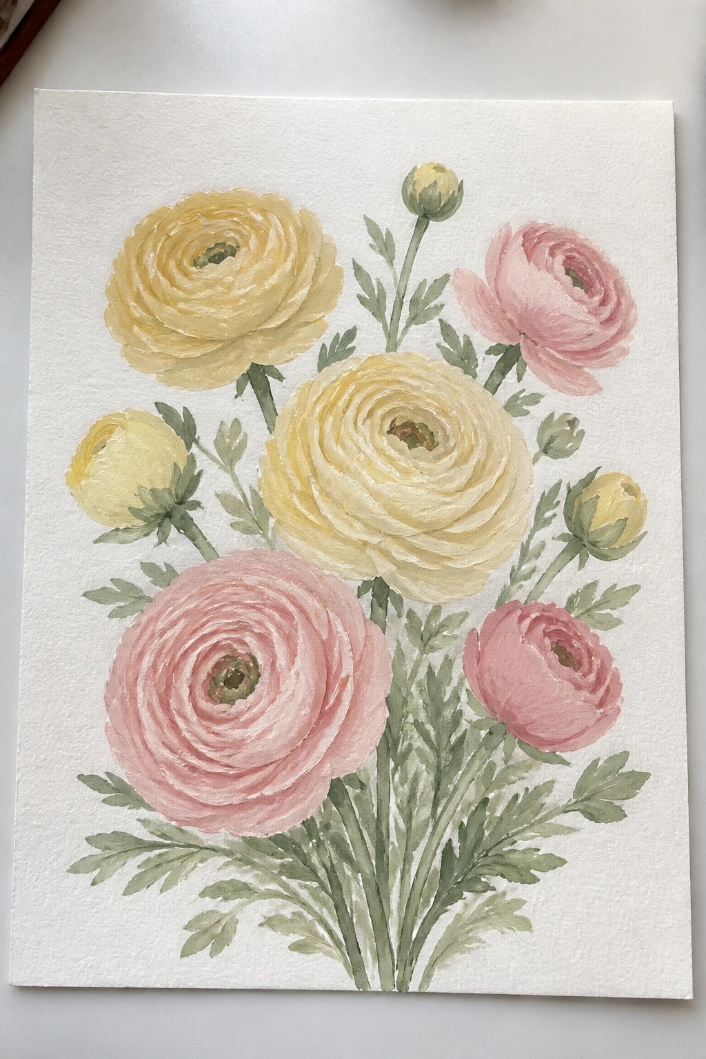 Watercolor painting of yellow and pink ranunculus flowers with green stems and leaves.