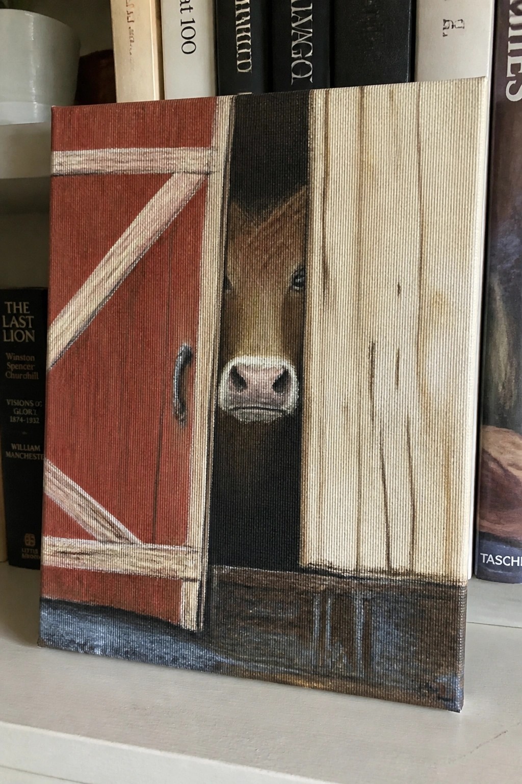Brown horse peeking through red barn door in painting on bookshelf