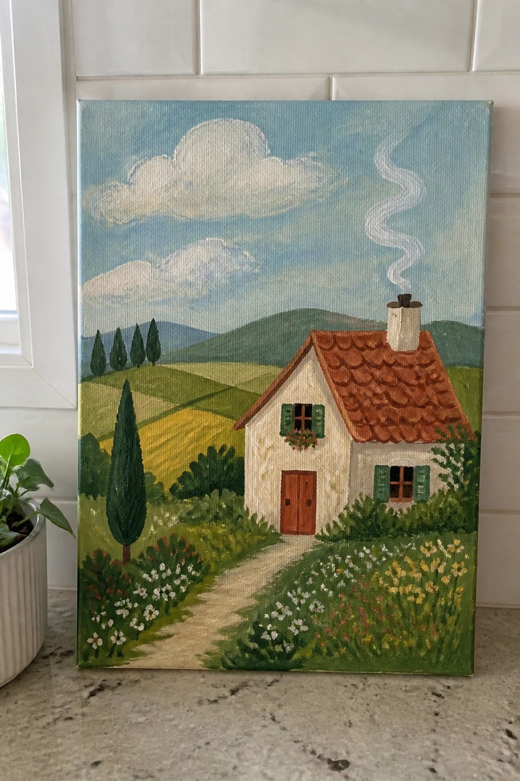 Painting of white cottage with red roof, smoking chimney, path, and green fields.