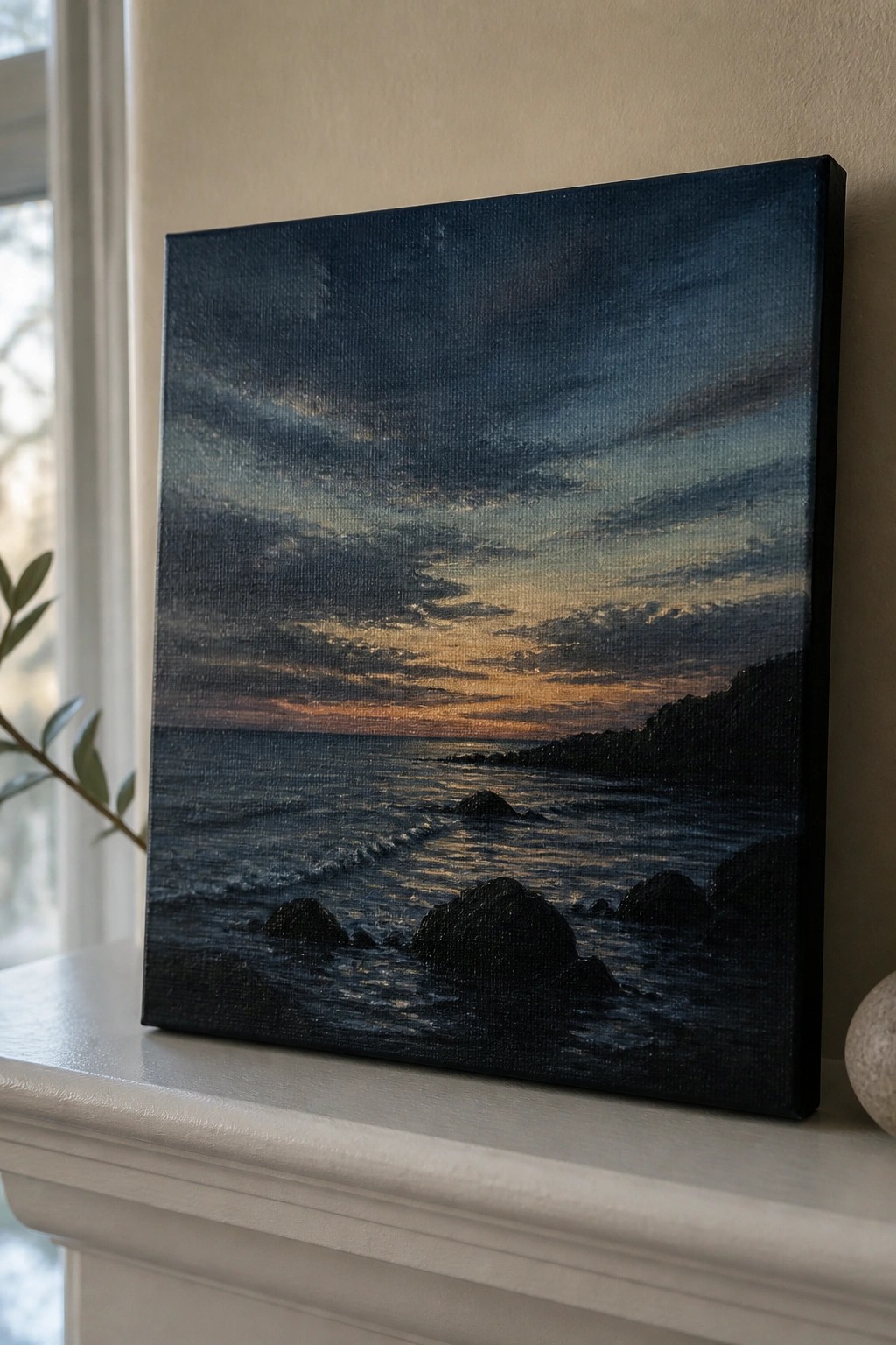 Realistic seascape painting of sunset over rocky ocean on white mantelpiece