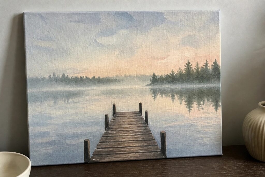 Painting of wooden dock over calm lake at sunset with potted plant nearby